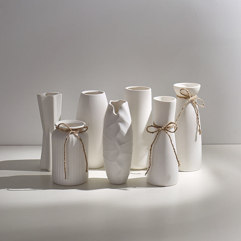 A collection of colorful ceramic mini flower vase variants styled on a shelf